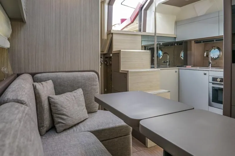 Yacht Photos Pics Modern interior of 2022 Cranchi M44HT yacht with cozy seating and sleek kitchen design.