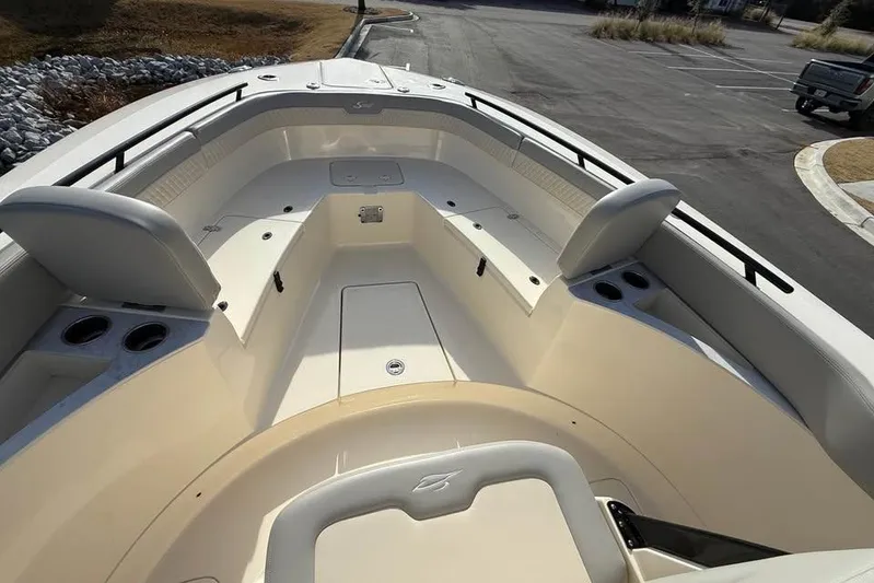  Yacht Photos Pics 2026 Scout 277 LXF boat interior with seating and cup holders in a parking lot.