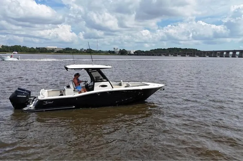  Yacht Photos Pics 2026 Scout 277 LXF boat cruising on a calm river under a cloudy sky.