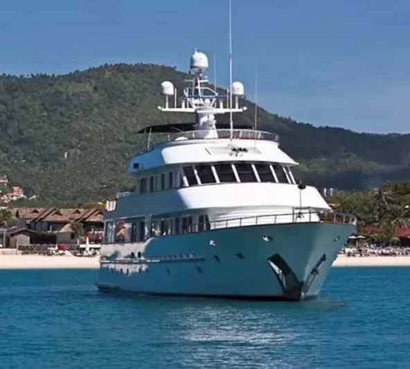 Ligaya Yacht Photos Pics Luxury yacht "Ocean Pacifico Diana" 2002, anchored near scenic coastline with lush hills.