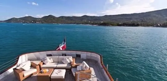 Ligaya Yacht Photos Pics Luxurious yacht deck with seating, Ocean Pacifico Diana, 2002, overlooking serene ocean and distant hills.