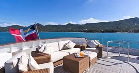 Ligaya Yacht Photos Pics Luxurious yacht deck with seating, ocean view, and flag; Ocean Pacifico Diana 2002 model.