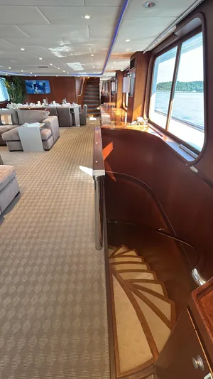 Ligaya Yacht Photos Pics Luxurious yacht interior with elegant staircase, plush seating, and scenic ocean views.