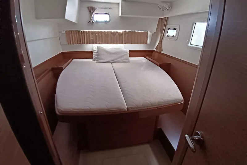  Yacht Photos Pics Interior cabin of 2019 Lagoon 42 catamaran with cozy bed and windows.