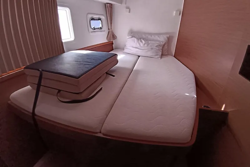  Yacht Photos Pics Cozy cabin interior of 2019 Lagoon 42 catamaran with bed and window.