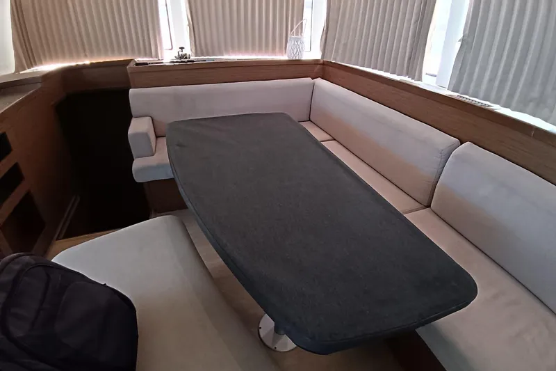  Yacht Photos Pics Interior of 2019 Lagoon 42 yacht with cushioned seating and table.