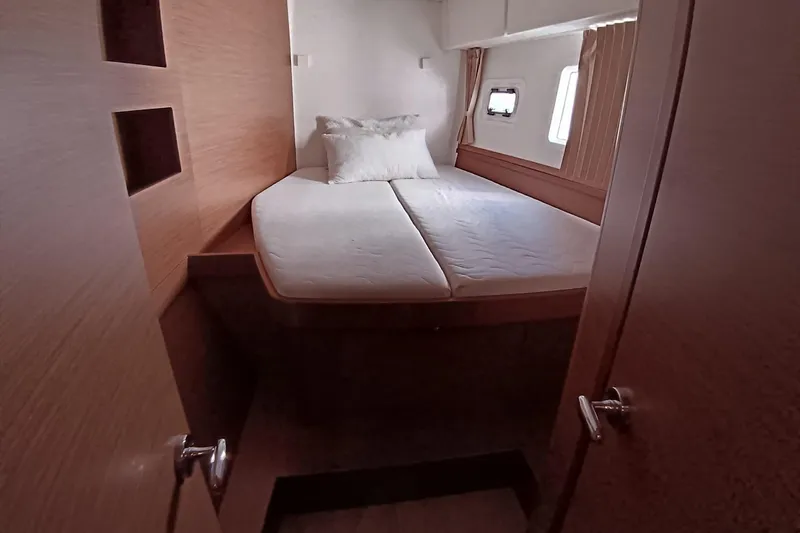  Yacht Photos Pics Cozy cabin interior of 2019 Lagoon 42 catamaran with bed and window.