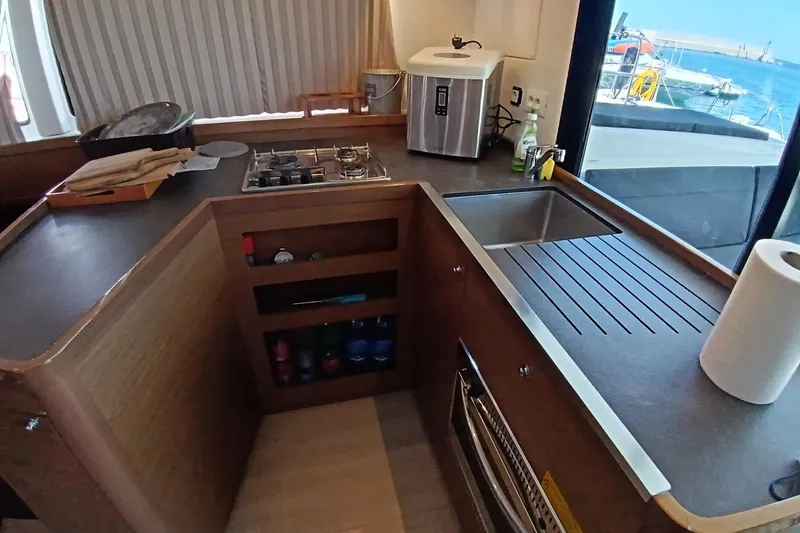  Yacht Photos Pics Modern kitchen interior of 2019 Lagoon 42 catamaran with stove, sink, and ocean view.