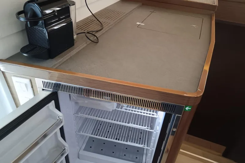  Yacht Photos Pics 2019 Lagoon 42 yacht kitchen with open fridge and coffee maker on counter.