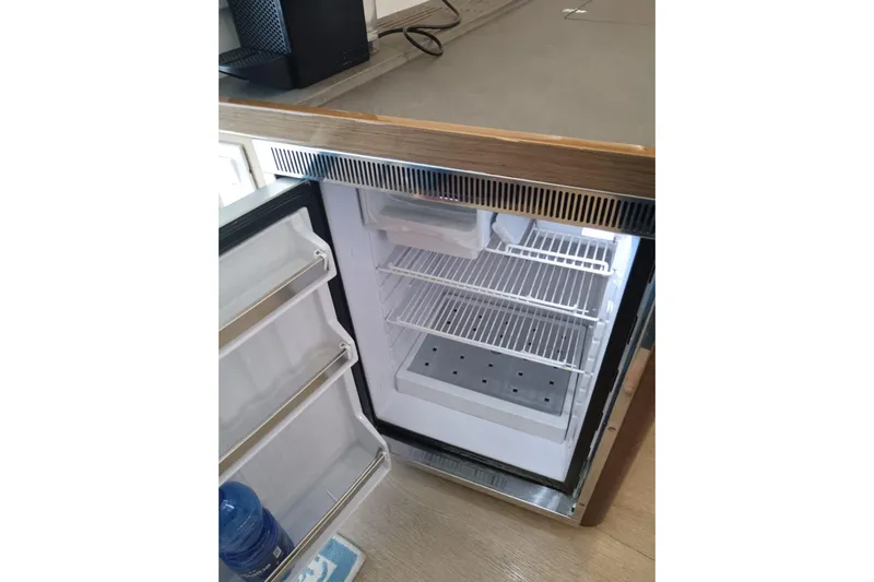  Yacht Photos Pics Open fridge inside 2019 Lagoon 42 yacht, showcasing shelves and door storage.