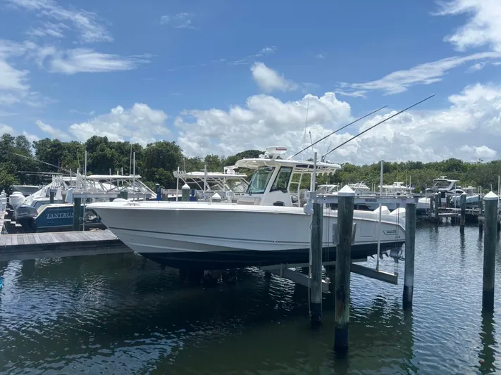  Yacht Photos Pics 2019 Boston Whaler 330 Outrage boat docked at marina under blue sky.