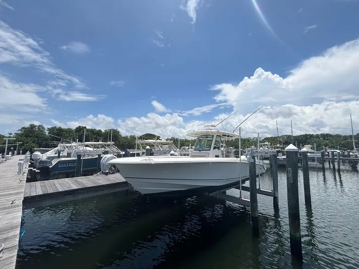  Yacht Photos Pics 2019 Boston Whaler 330 Outrage docked at marina under clear blue sky.