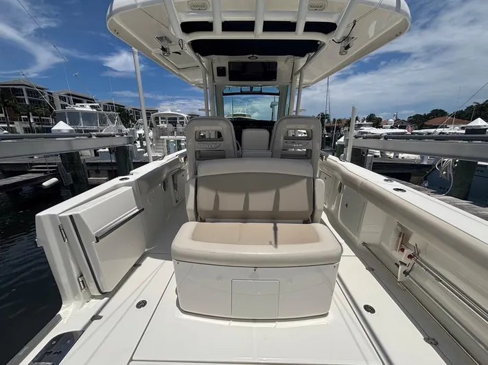  Yacht Photos Pics 2019 Boston Whaler 330 Outrage boat interior at marina, showcasing seating and deck features.