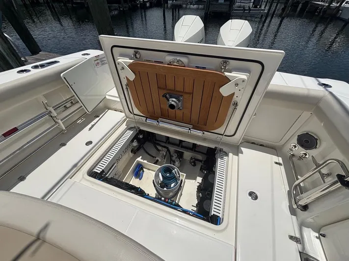  Yacht Photos Pics 2019 Boston Whaler 330 Outrage boat with open engine compartment at dock.