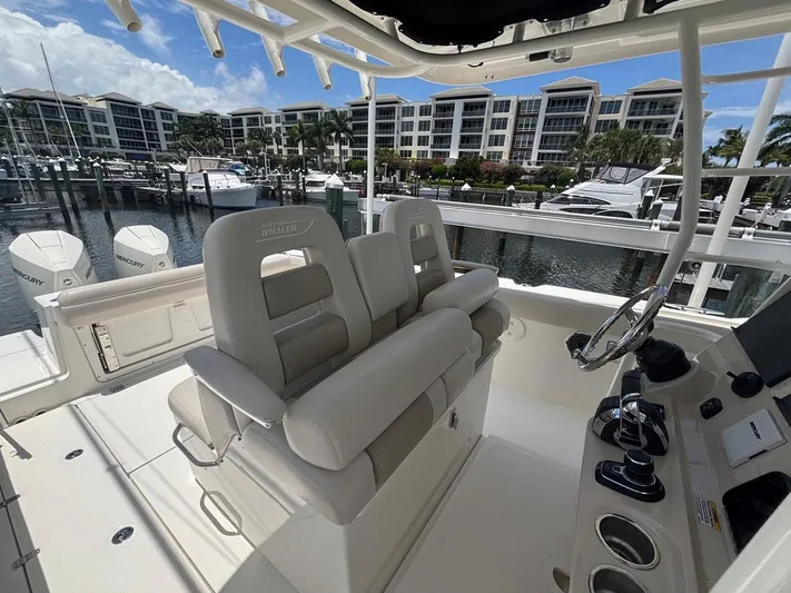  Yacht Photos Pics 2019 Boston Whaler 330 Outrage boat interior with helm and seating at marina.