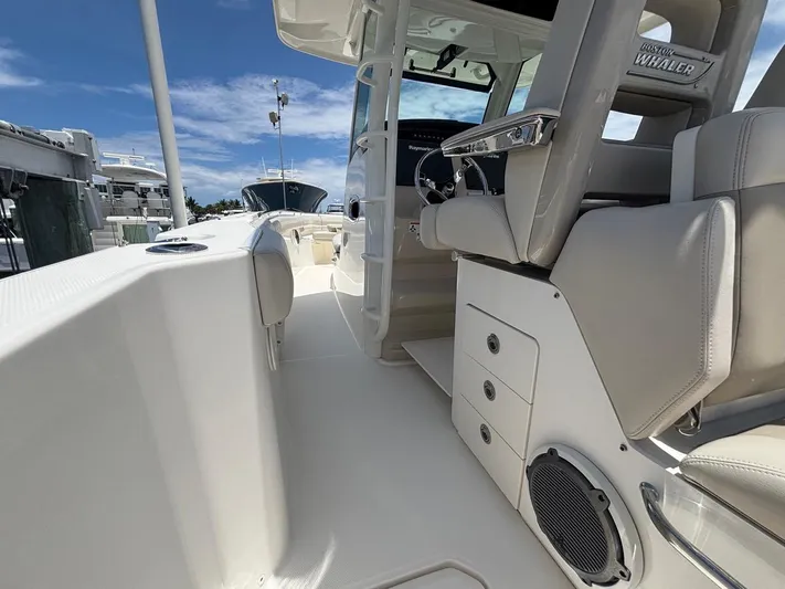  Yacht Photos Pics 2019 Boston Whaler 330 Outrage boat interior with helm and seating under clear blue sky.