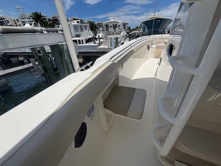  Yacht Photos Pics 2019 Boston Whaler 330 Outrage boat docked, showcasing sleek design and spacious deck.
