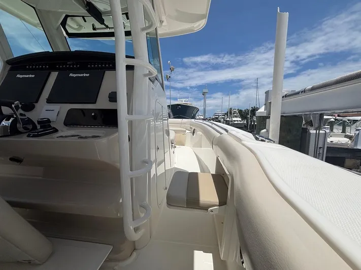  Yacht Photos Pics 2019 Boston Whaler 330 Outrage boat interior with helm and seating, docked under blue sky.