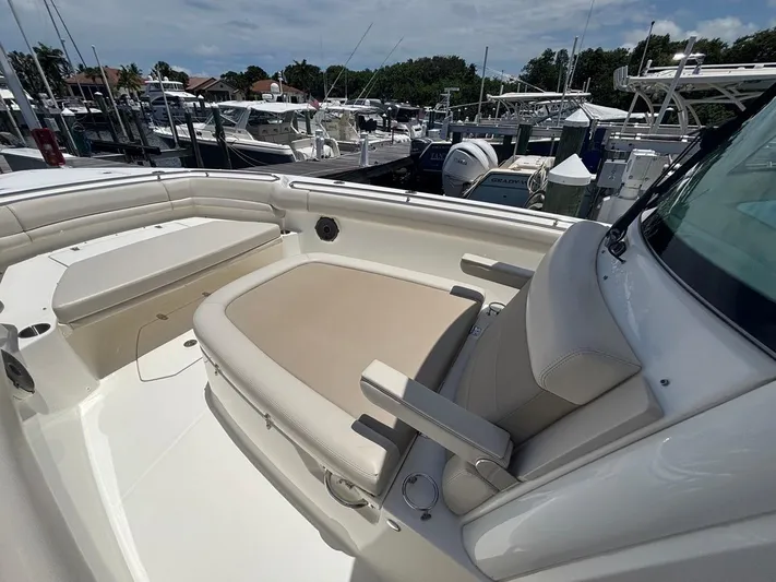  Yacht Photos Pics 2019 Boston Whaler 330 Outrage boat interior with cushioned seating at marina.