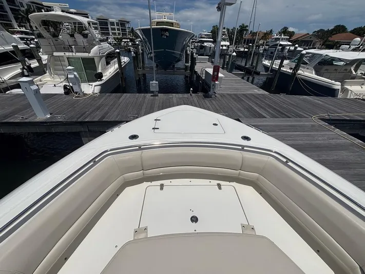  Yacht Photos Pics 2019 Boston Whaler 330 Outrage docked at a marina, surrounded by other boats.