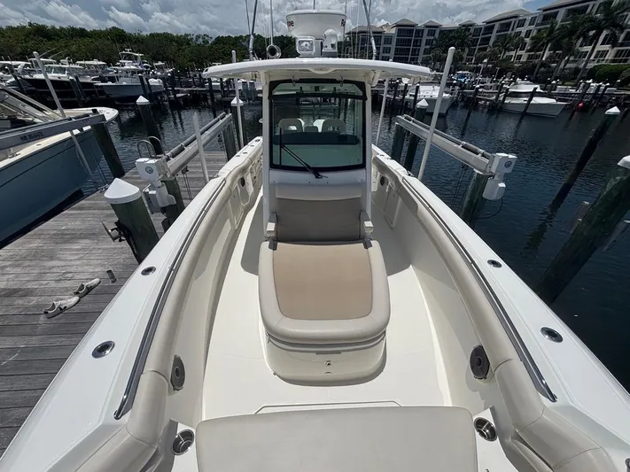  Yacht Photos Pics 2019 Boston Whaler 330 Outrage boat docked at marina, showcasing spacious deck layout.