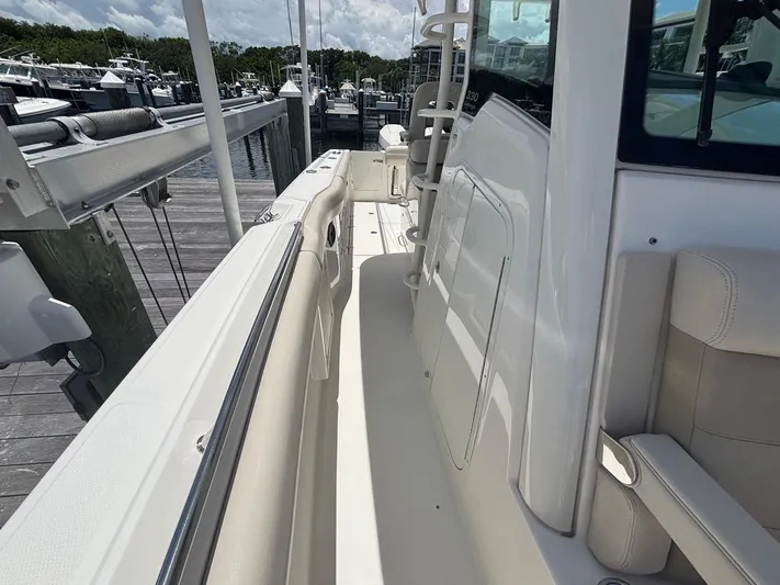 Yacht Photos Pics 2019 Boston Whaler 330 Outrage boat docked, showcasing sleek deck and seating area.