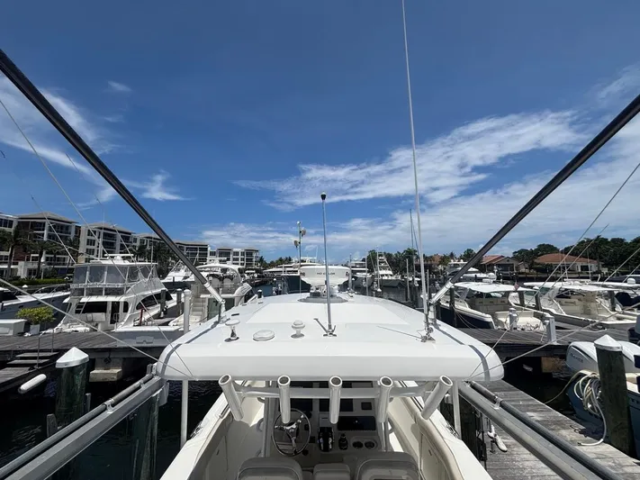  Yacht Photos Pics 2019 Boston Whaler 330 Outrage docked at a marina under a clear blue sky.