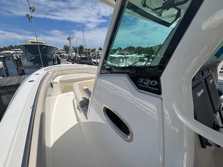  Yacht Photos Pics 2019 Boston Whaler 330 Outrage boat docked at marina under clear blue sky.