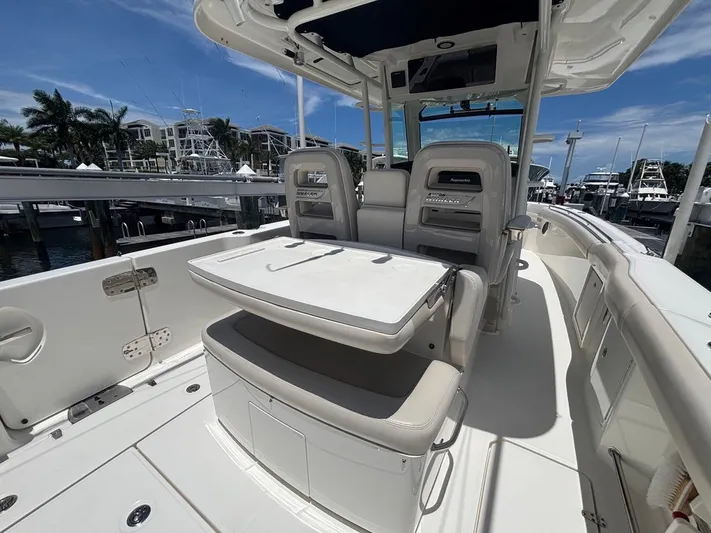  Yacht Photos Pics 2019 Boston Whaler 330 Outrage boat interior with seating and table, docked at marina.