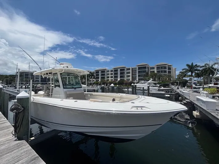  Yacht Photos Pics 2019 Boston Whaler 330 Outrage docked at marina, clear sky, waterfront buildings.