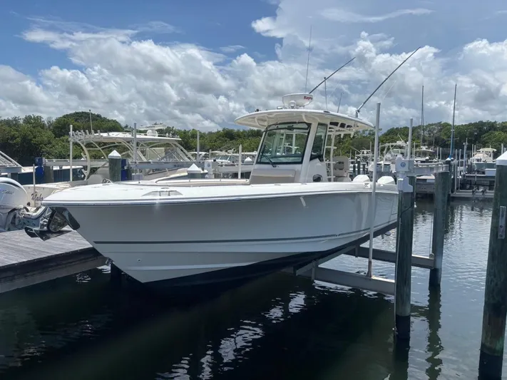  Yacht Photos Pics 2019 Boston Whaler 330 Outrage boat docked at marina under cloudy sky.
