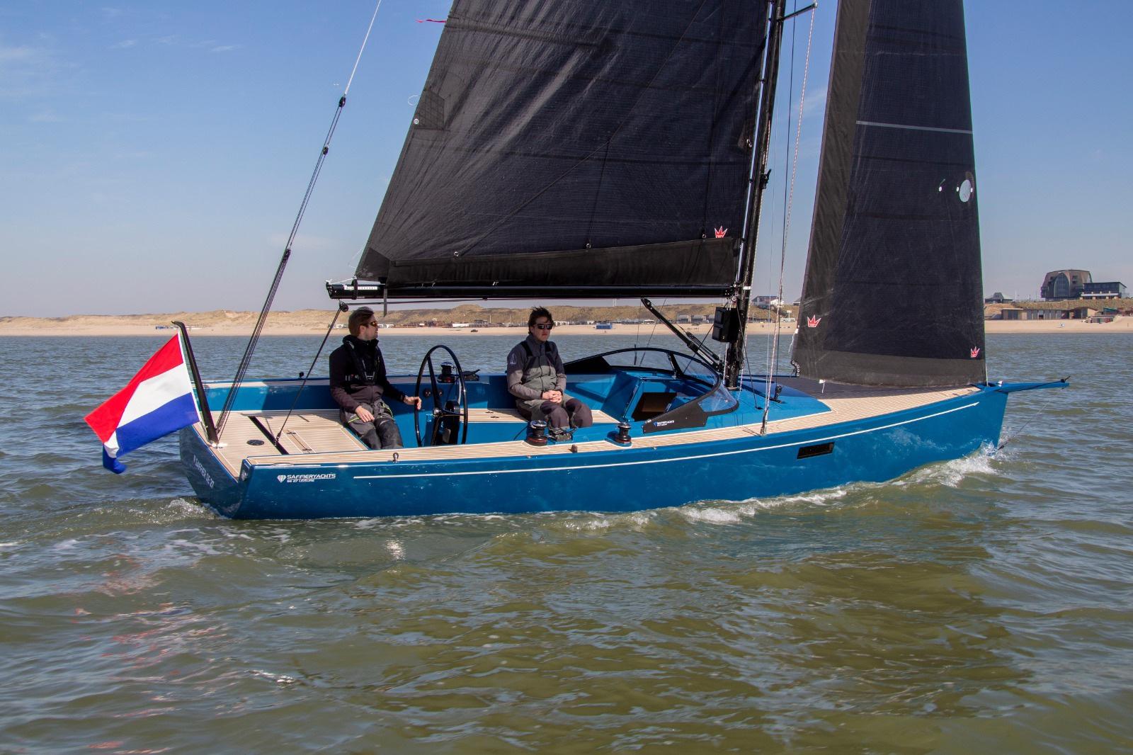 2026 Saffier Se 27 Leisure sailboat on water, featuring blue hull and black sails.