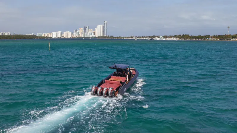 2023 Skipper-bsk 42 Quad 450r Yacht Photos Pics Skipper-BSK 42 boat cruising in blue waters, city skyline in background, 2023 model.