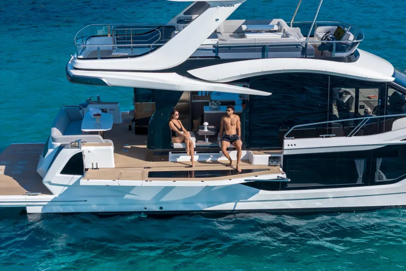  Yacht Photos Pics 2026 Galeon 560 Fly yacht with people relaxing on deck in clear blue water.