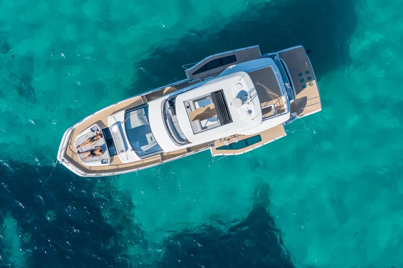  Yacht Photos Pics Aerial view of 2026 Galeon 560 Fly yacht on clear turquoise water.