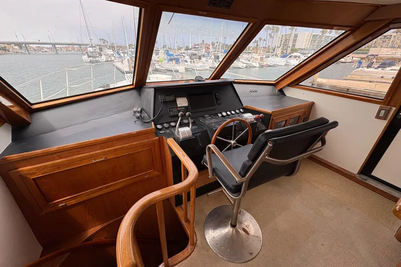 Majestic Z Yacht Photos Pics 1990 Angel Pilothouse interior with steering wheel, control panel, and marina view.