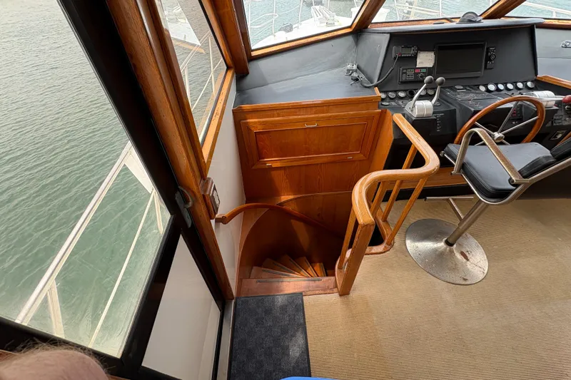 Majestic Z Yacht Photos Pics Interior of a 1990 Angel Pilothouse boat, featuring helm and wooden staircase.