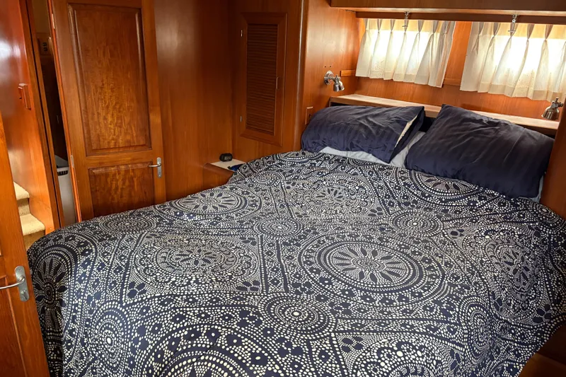 Majestic Z Yacht Photos Pics Cozy bedroom in 1990 Angel Pilothouse yacht with patterned bedding and wooden interior.