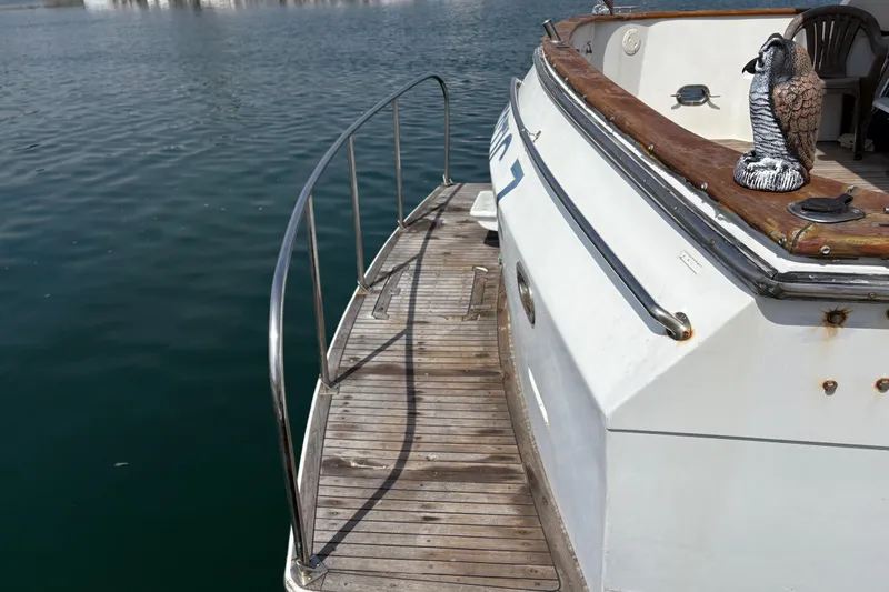 Majestic Z Yacht Photos Pics 1990 Angel Pilothouse boat with wooden deck and decorative owl statue.
