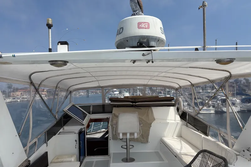 Majestic Z Yacht Photos Pics 1990 Angel Pilothouse boat interior with seating and navigation equipment, docked in a marina.