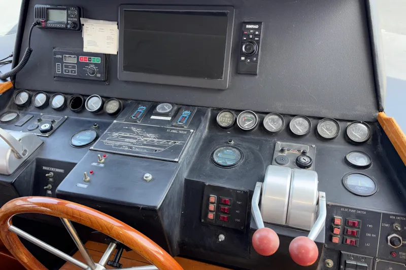 Majestic Z Yacht Photos Pics 1990 Angel Pilothouse control panel with gauges, switches, and steering wheel.