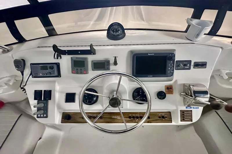 Ohana Yacht Photos Pics 1999 Mainship 390 Trawler helm with navigation instruments and steering wheel.