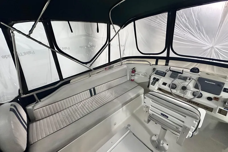 Ohana Yacht Photos Pics 1999 Mainship 390 Trawler helm with seating, steering wheel, and navigation equipment.