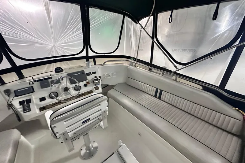 Ohana Yacht Photos Pics 1999 Mainship 390 Trawler helm with steering wheel, navigation equipment, and seating.