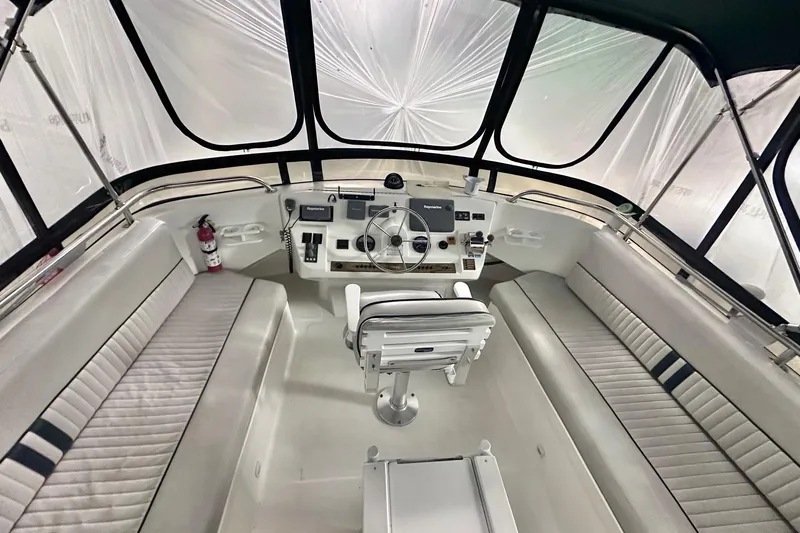 Ohana Yacht Photos Pics 1999 Mainship 390 Trawler helm with seating, steering wheel, and navigation equipment.