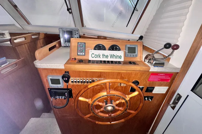 Ohana Yacht Photos Pics 1999 Mainship 390 Trawler helm with wooden wheel and navigation instruments.
