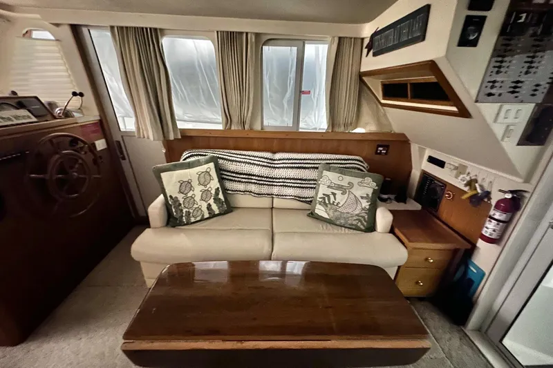 Ohana Yacht Photos Pics 1999 Mainship 390 Trawler interior with sofa, cushions, and wooden table.