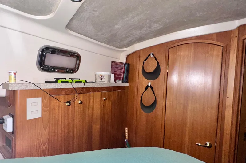 Ohana Yacht Photos Pics Interior of 1999 Mainship 390 Trawler with wooden cabinetry and porthole window.