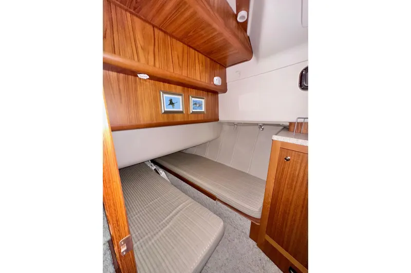 Ohana Yacht Photos Pics 1999 Mainship 390 Trawler cabin interior with wooden finish and cozy sleeping area.