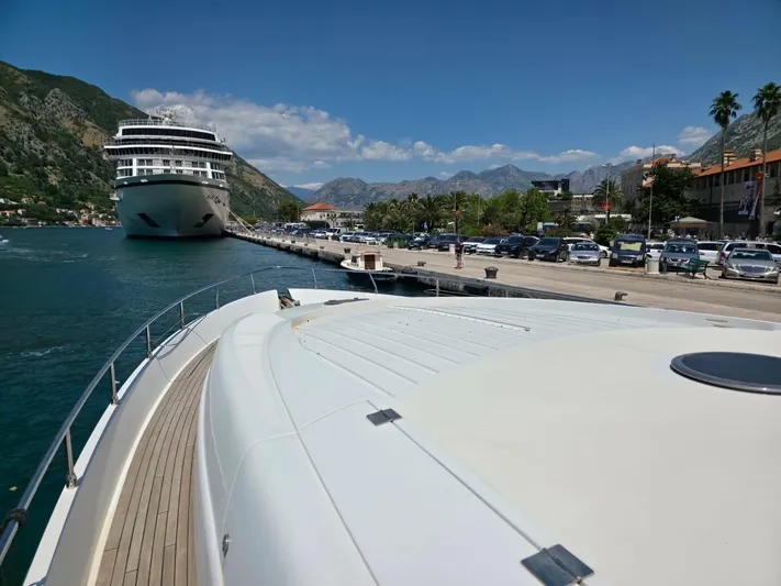 Evazione Yacht Photos Pics Luxury Pershing 67 yacht docked near a cruise ship in a scenic harbor, 2005 model.